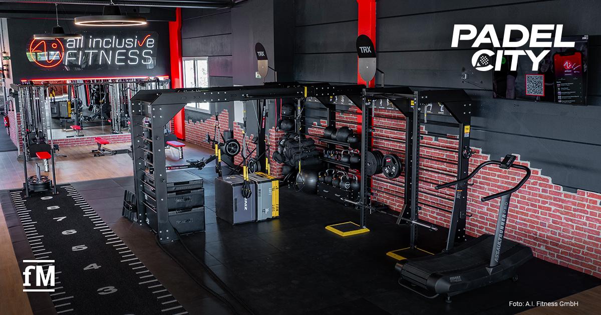 Partnerschaft von all inclusive Fitness und PadelCity Trainingsfläche im all inclusive Fitness-Studio mit Functional Rig, TRX-Systemen, Laufband und Hanteln in modernem Industrial-Design.