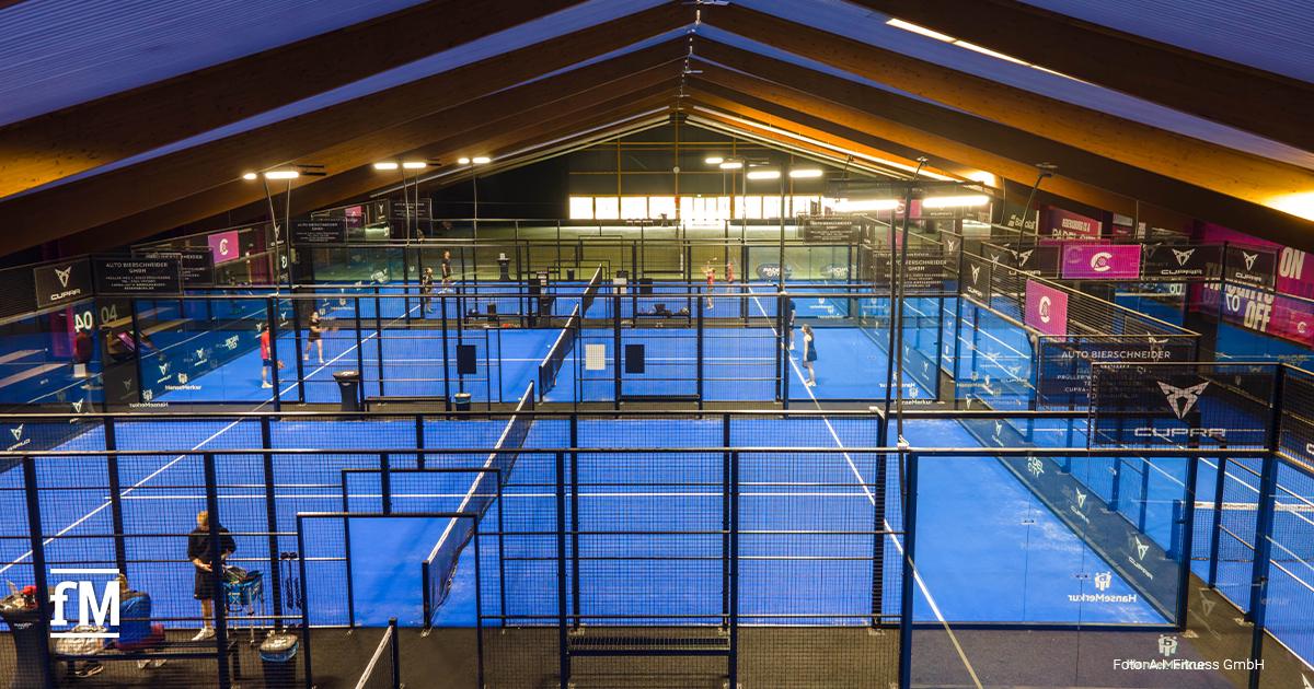 Übersicht über mehrere blaue Padel-Courts in einer modernen Indoor-Halle von PadelCity während des Spielbetriebs