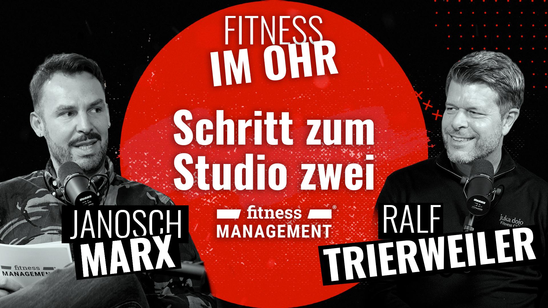 Zwei Männer (links Janosch Marx, rechts Ralf Trierweiler) sitzen sich in einem Podcaststudio gegenüber und sprechen in Mikrofone, im Hintergrund ist ein roter Kreis mit dem Schriftzug 'Fitness im Ohr' und 'Schritt zum Studio zwei' zu sehen.