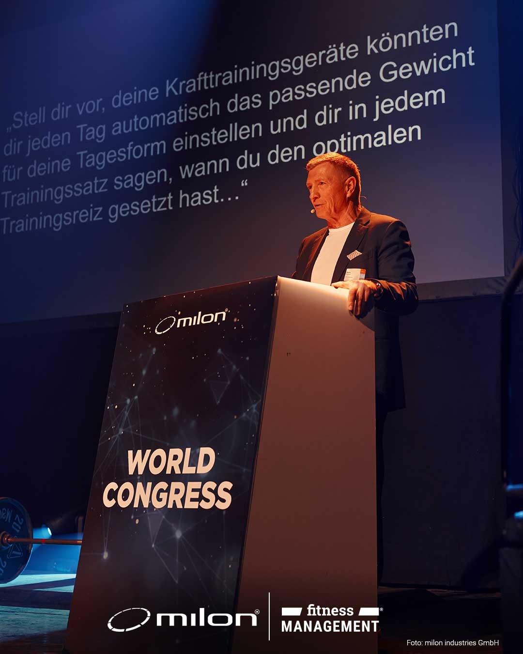 Mann steht hinter einem Rednerpult mit der Aufschrift „WORLD CONGRESS“ auf einer Bühne.