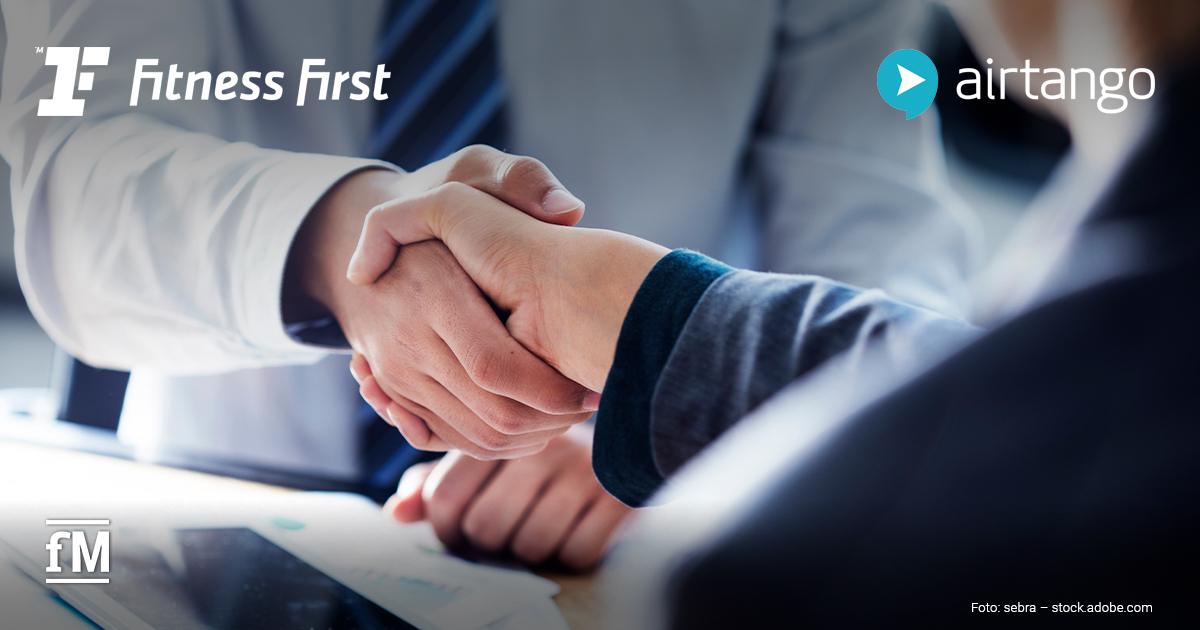 Zwei Personen im Businessumfeld geben sich über einem Tisch die Hand. Im Bild sind die Logos von Fitness First und airtango zu sehen