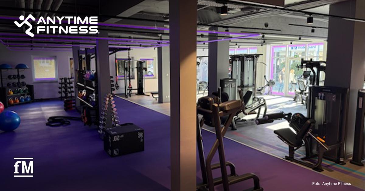 Anytime Fitness Eröffnung Hamm Fitnessstudio-Innenraum mit Kraftgeräten, Functional-Training-Bereich, violettem Boden und Anytime Fitness Logo.