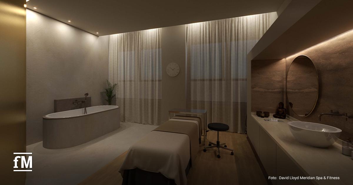 Behandlungsraum mit Massagebank, Badewanne, Waschbecken, Spiegel und Vorhängen vor Fenstern.