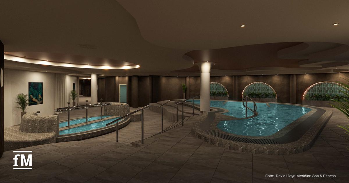 Innenpool mit blauem Wasser, beleuchteten Liegen und dunklen Wandfliesen.