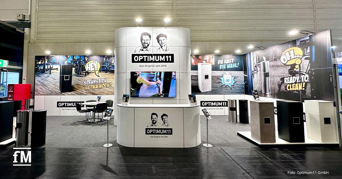Messestand von Optimum11 auf der FIBO mit verschiedenen Spenderlösungen für Desinfektionstücher.