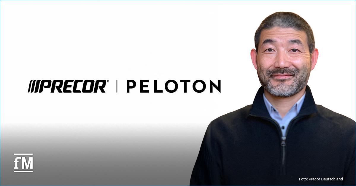 Rechts im Bild eine stehende Person (Precor Präsident Ean Reves,) frontal zur Kamera, neutraler Hintergrund, links daneben großflächig das Precor | Peloton Logo, unten links kleines fM-Logo, unten rechts Bildcredit, Person trägt dunkle Jacke, Oberkörperaufnahme, Blickrichtung nach vorn.