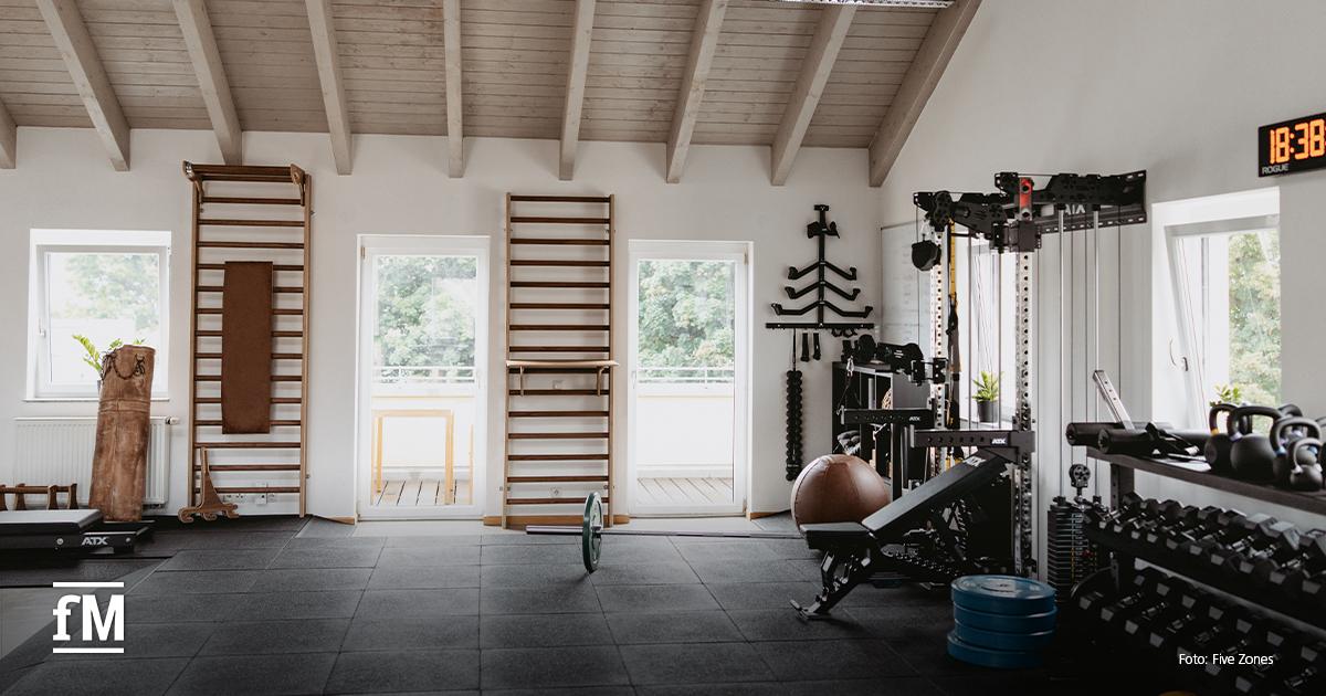 Helles Fitnessstudio mit hohen Decken, Sprossenwänden und vielseitigen Trainingsmöglichkeiten.