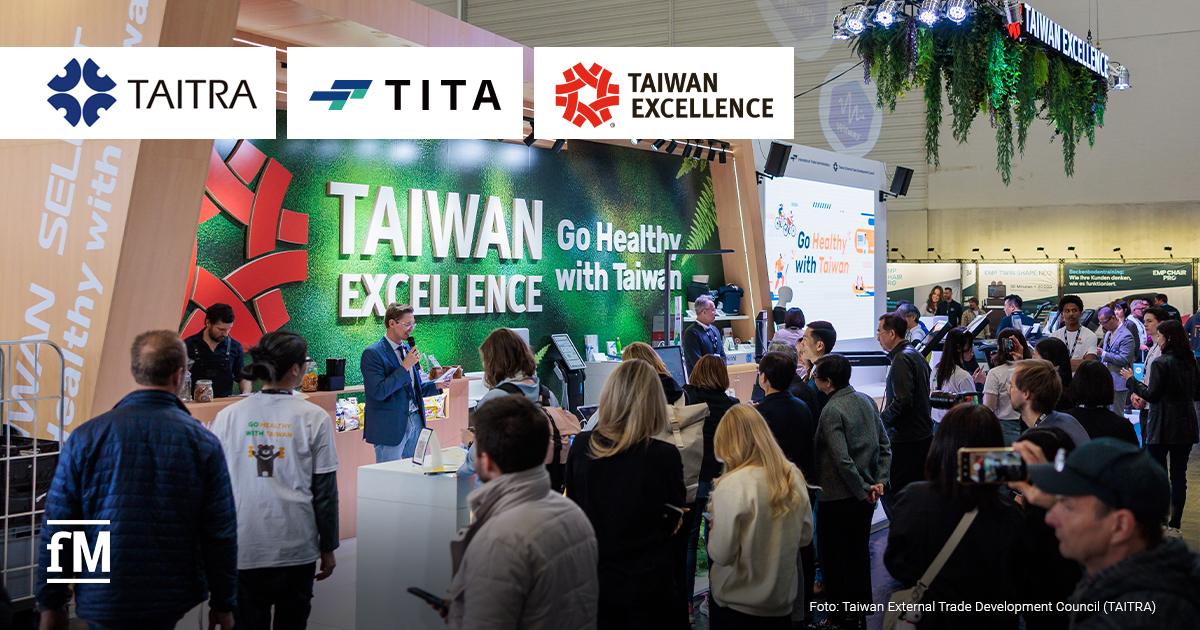 Taiwan Excellence FIBO 2026 Messestand mit großem Schriftzug Taiwan Excellence, davor zahlreiche Besucher, Bühne mit sprechender Person, Beleuchtung und Pflanzeninstallation hängt im oberen Bereich von der Decke.