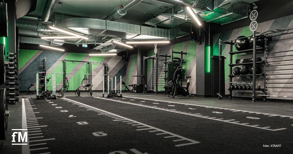 Functional-Trainingsfläche mit Turf-Bahnen, Racks, Kettlebells und offenem Performance-Setup.