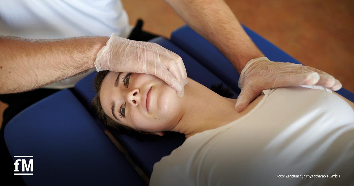 Frau liegt auf einer blauen Therapieliege, während eine Person mit Handschuhen den Kopf und Schulterbereich behandelt. Sichtbar sind Arme, Hände und Oberkörper der behandelnden Person.