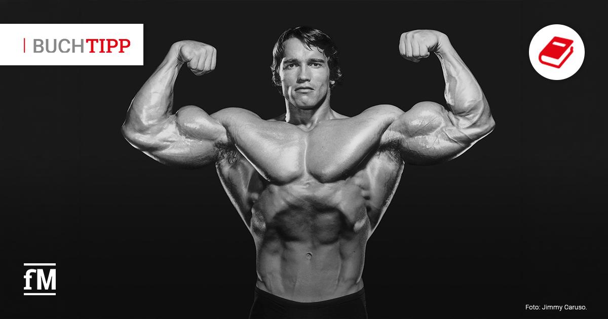 Buchtipp: ARNOLD von Dian Hanson Schwarz-weißes Foto eines Bodybuilders mit erhobenen Armen vor schwarzem Hintergrund, links oben steht „BUCHTIPP“.