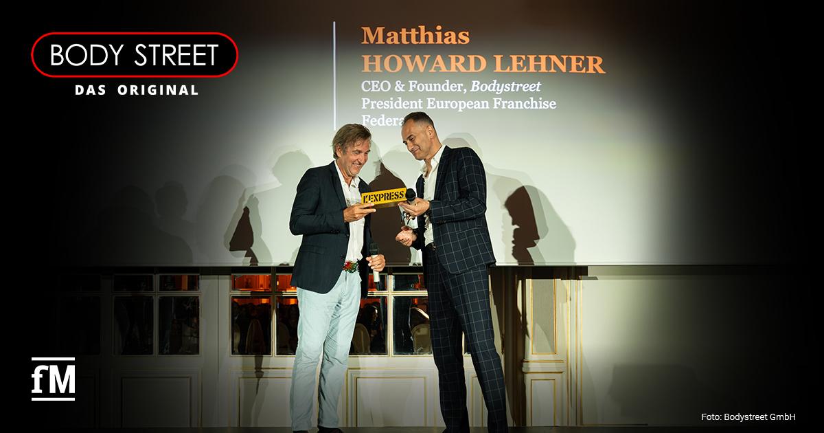 Matthias Lehner Bodystreet Auszeichnung Matthias H. Lehner nimmt auf einer Bühne einen L’Express-Award entgegen