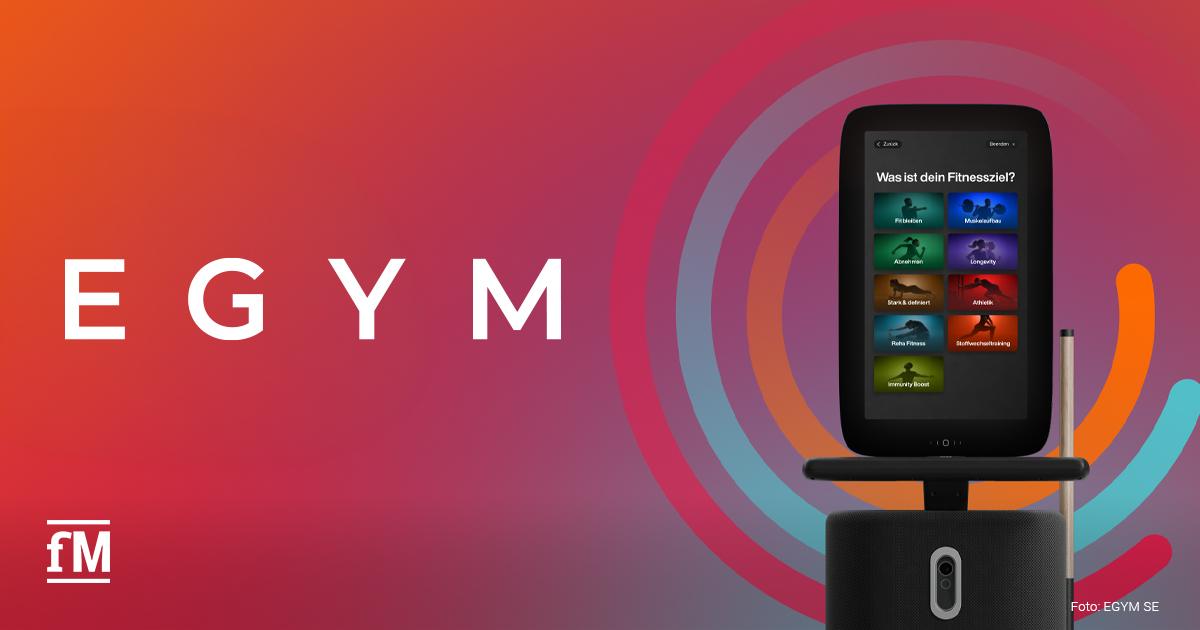 EGYM BioAge und neues Longevity-Trainingsprogramm Großes weißes EGYM-Logo auf orange-rot-violettem Farbverlauf. Rechts steht ein Trainingsgerät mit integriertem Bildschirm.
