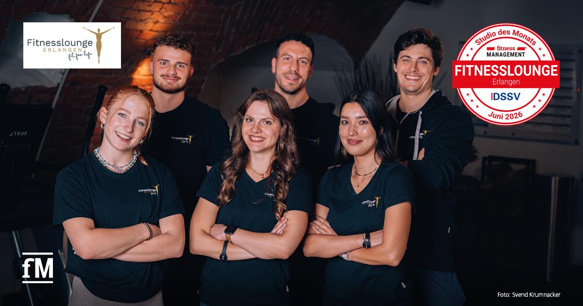 Fitnesslounge Erlangen Sechs Mitarbeitende der Fitnesslounge Erlangen stehen in zwei Reihen vor einer Backsteinwand. Alle tragen dunkle Oberteile mit sichtbarem Fitnesslounge-Logo. Oben links ist das Logo der Fitnesslounge sichtbar, rechts das Siegel „Studio des Monats Juni 2026“.