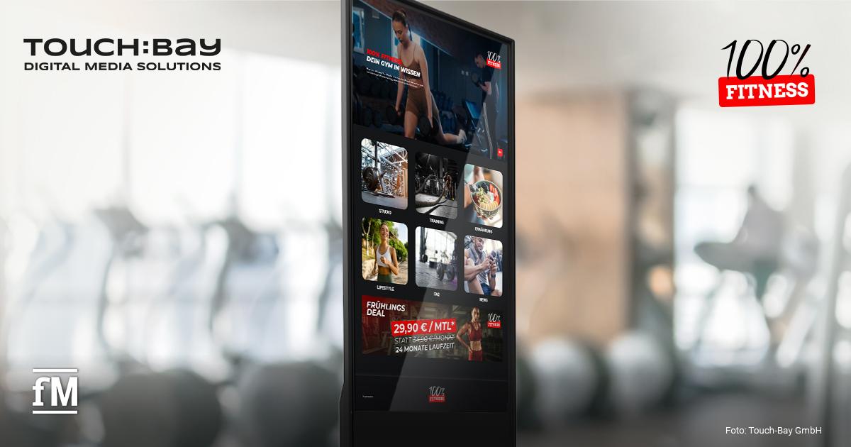 TOUCH:BAY 100% Fitness Kooperation Interaktives TOUCH:BAY-Display mit Fitnessinhalten und Serviceangeboten in einem Fitnessstudio