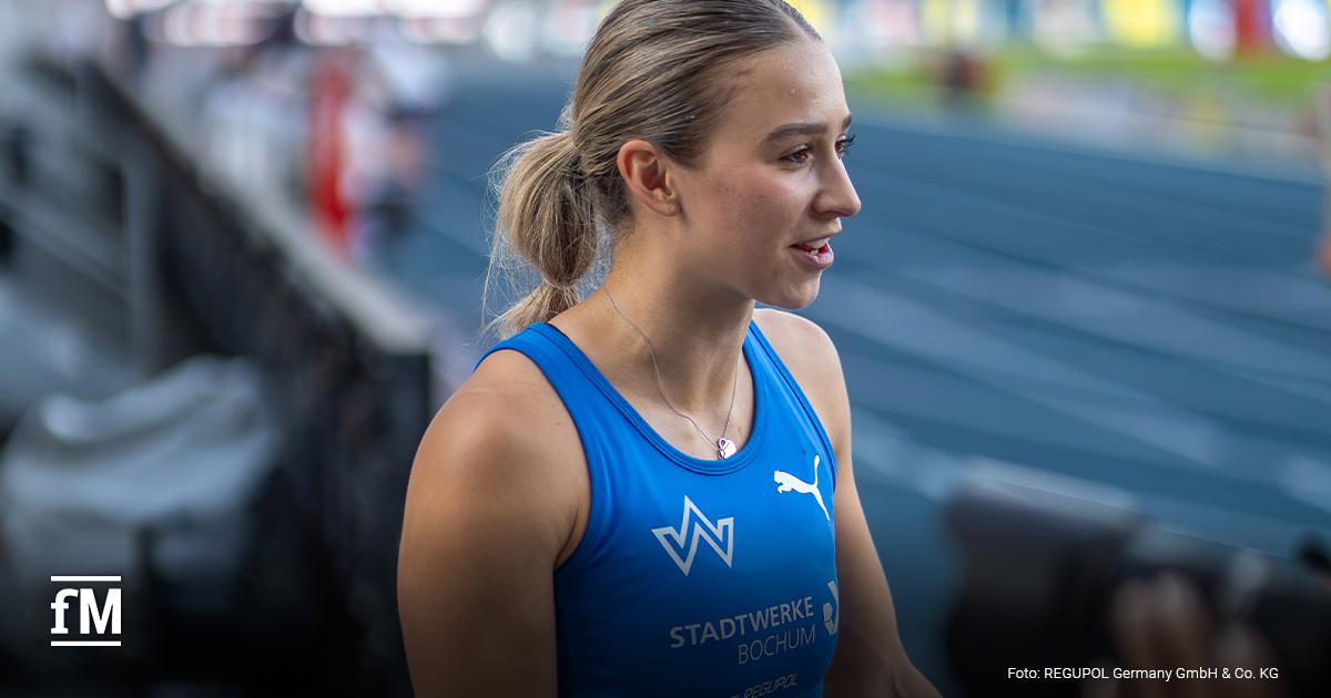 Jolina Ernst im blauen Trikot am Rand einer Laufbahn.