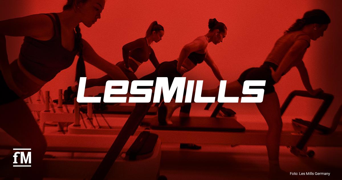 LES MILLS REFORMER Vier Frauen trainieren auf Reformer-Geräten vor rotem Hintergrund mit LES-MILLS-Schriftzug