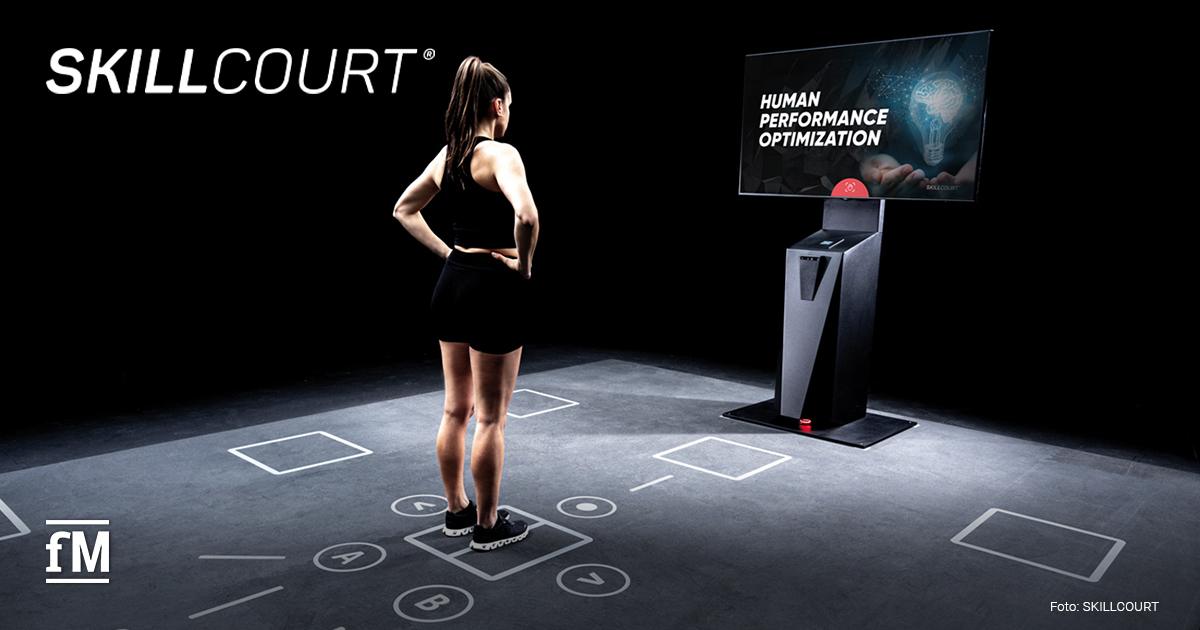 SKILLCOURT Seed-Finanzierung Eine Athletin steht auf markiertem Trainingsfeld vor einem SKILLCOURT-Bildschirm.