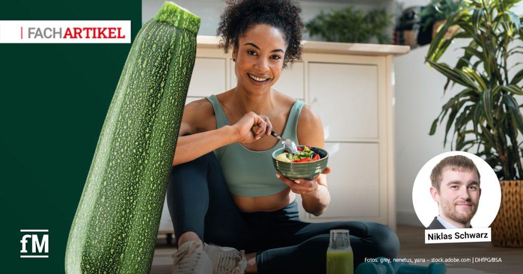 Sportliche Person bereitet eine vegane Mahlzeit mit Gemüse, Hülsenfrüchten und Getreide zu.