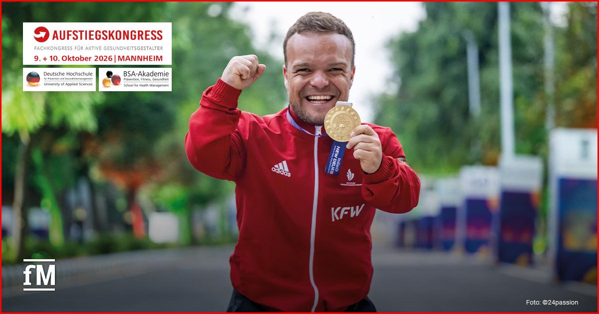 Aufstiegskongress 2026: Keynote von Niko Kappel Niko Kappel hält lächelnd eine Medaille in der Hand und hebt die andere Faust.