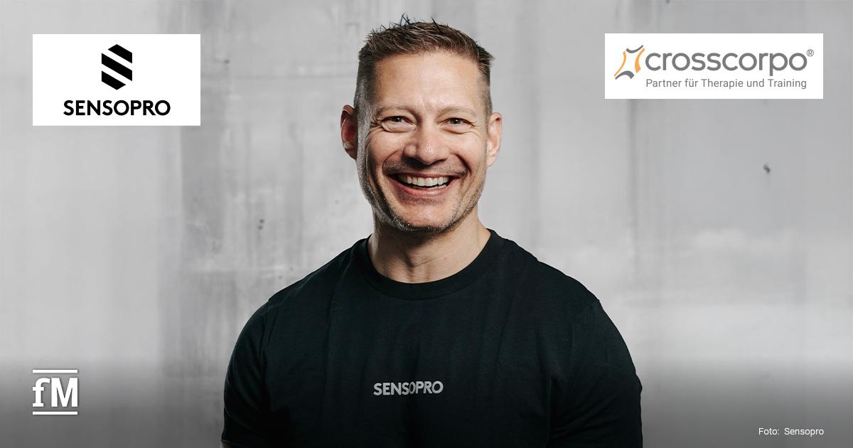 Sensopro x crosscorpo Porträt eines lachenden Mannes im schwarzen Sensopro-T-Shirt vor grauem Hintergrund. Oben sind die Logos von Sensopro und crosscorpo.