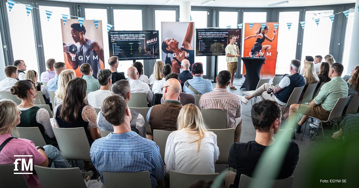 EGYM-Kundenevent München Ein Referent spricht beim EGYM-Kundenevent vor sitzenden Teilnehmern in einem Veranstaltungsraum