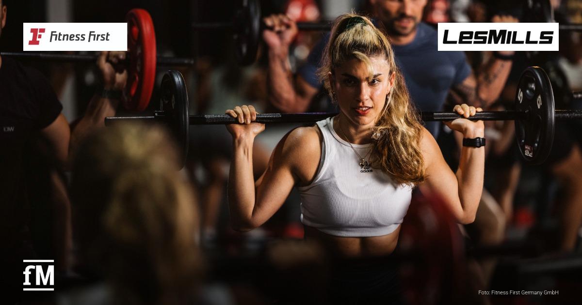 Fitness First Les Mills Kooperation Instruktor-Auditions rau trainiert mit einer Langhantel in einem Groupfitness-Kurs; Logos von Fitness First und Les Mills