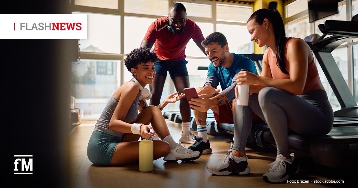 Fitness Flash News #09/2026 KW 37 Vier Personen in Sportkleidung sitzen und stehen gemeinsam in einem Fitnessstudio
