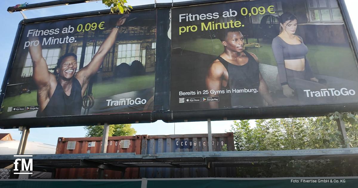 Fitvertise TrainToGo OOH-Kampagne TrainToGo-Werbekampagne auf einer großflächigen Außenwerbeanlage mit zwei Fitnessmotiven und dem Slogan „Fitness ab 0,09 € pro Minute“.