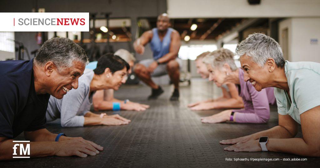 Ältere Menschen trainieren gemeinsam auf Matten in einem Fitnessstudio.