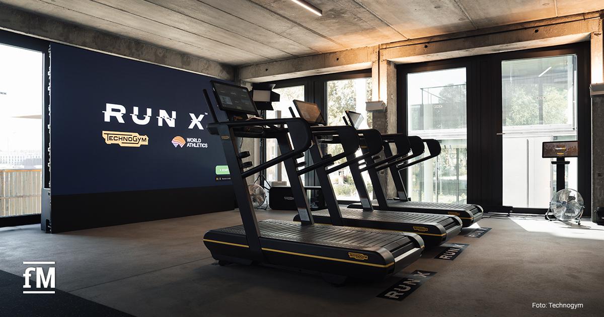 Mehrere Technogym-Laufbänder vor einer großen RUN-X-Anzeige in einem Veranstaltungsraum