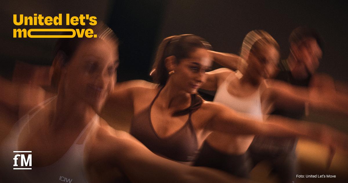 United let’s move. Umfrage Gruppe beim gemeinsamen Fitnesstraining mit „United let’s move.“-Logo.