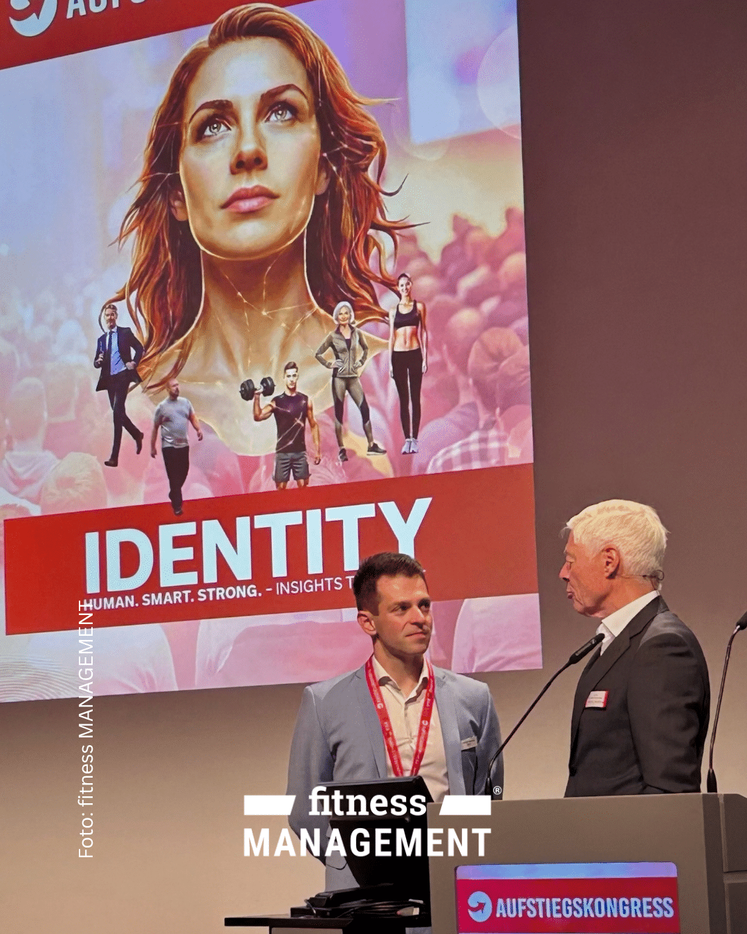 Zwei Männer stehen auf der Bühne des Aufstiegskongresses 2026 vor einer großen Präsentationsfläche mit dem Schriftzug „IDENTITY“.