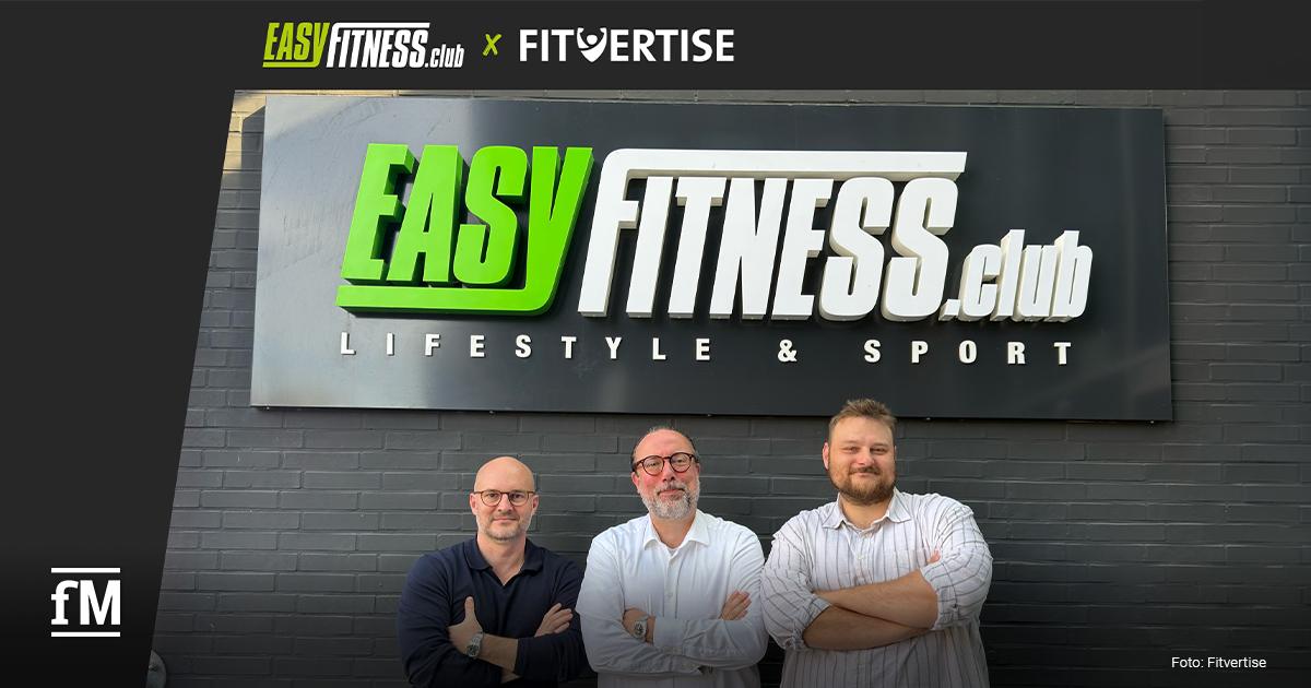 Fitvertise x EASYFITNESS Drei Männer stehen mit verschränkten Armen vor einer dunklen Backsteinwand unter dem großen Schriftzug „EASYFITNESS.club – Lifestyle & Sport“. Am oberen Bildrand sind die Logos von EASYFITNESS.club und Fitvertise zu sehen.