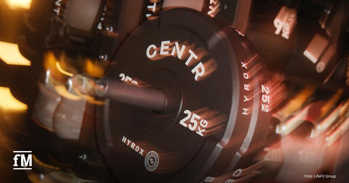 Nahaufnahme schwarzer HYROX-Gewichtsscheiben mit der Aufschrift „25 KG“ an einer Hantelstange