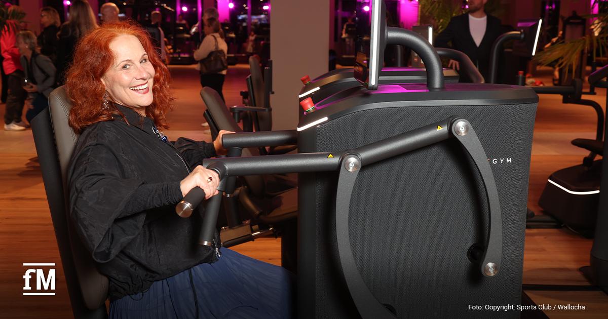 Christiane Leuchtmann sitzt lächelnd an einem Krafttrainingsgerät im Sports Club