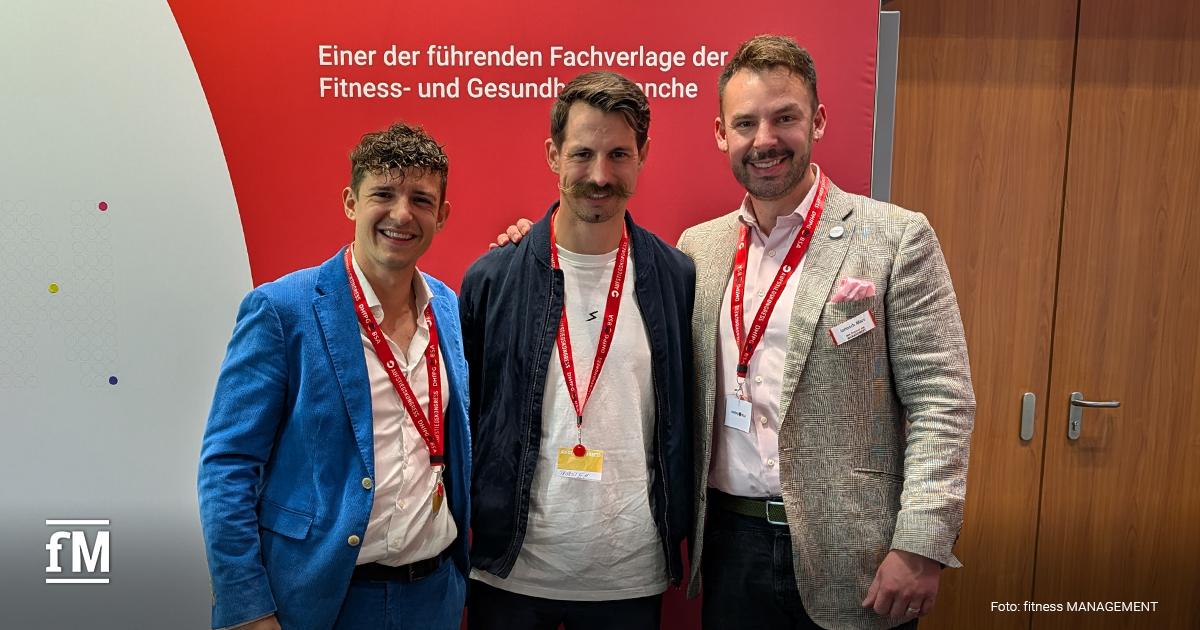 Sportable Thorsten Mierau Drei lächelnde Männer mit roten Veranstaltungsbändern stehen nebeneinander vor einer rot-weißen Messewand.