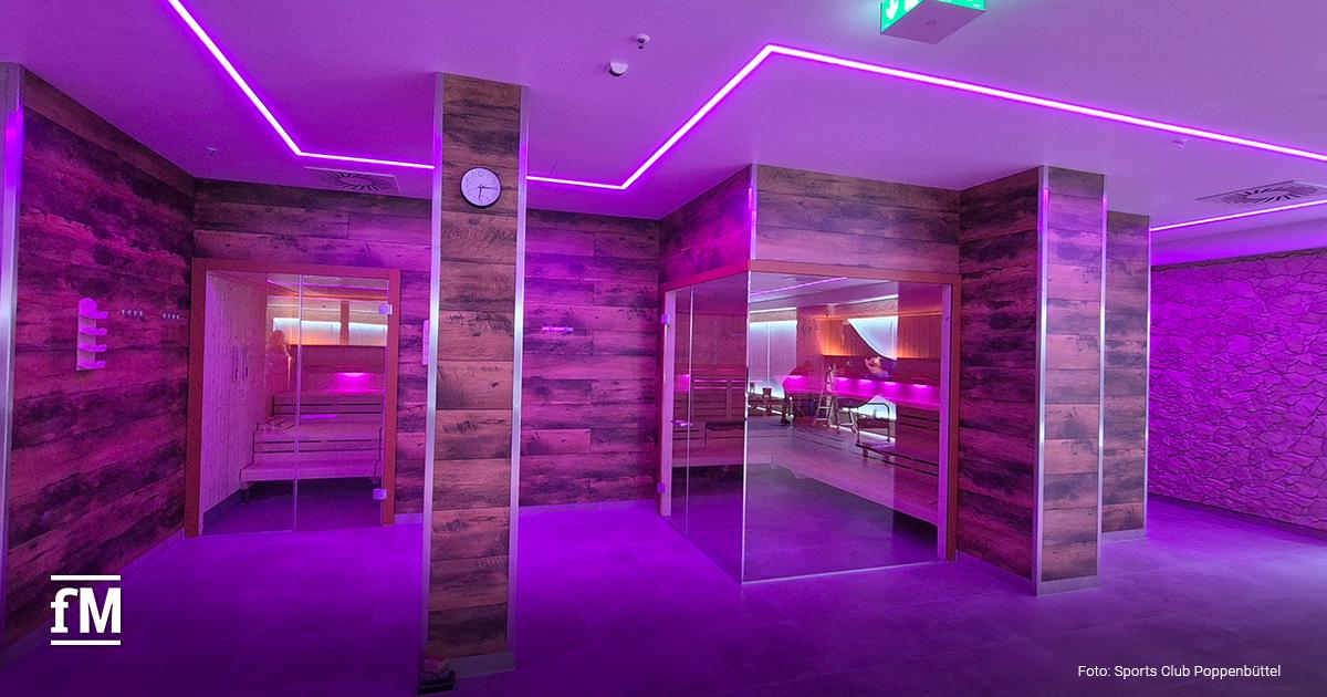 Zwei Saunen in einem mit Holz verkleideten Wellnessbereich mit violetter Beleuchtung