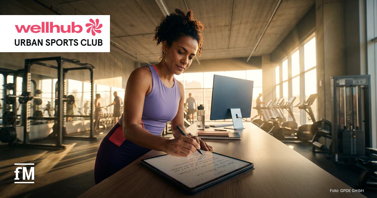 wellhub Urban Sports Club Wachstumsbericht 2026 Frau schreibt an einem digitalen Bildschirm an einem Tresen in einem Fitnessstudio