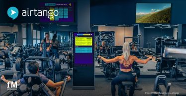 Fitnessstudio mit Trainierenden, digitalen Kursplananzeigen und einer Navigator-Stele von airtango