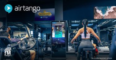 Trainingsbereich mit Sportgeräten, Trainierenden, digitalen TV-Screens und einem interaktiven airtango Navigator.