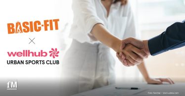 Logos von Basic-Fit und Wellhub neben einem Handschlag als Symbol für die erweiterte Partnerschaft