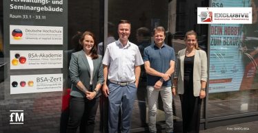 Vier Personen stehen vor dem Verwaltungs- und Seminargebäude der DHfPG in Saarbrücken.