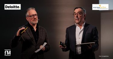 Zwei Männer (Herman Rutgers und Karsten Hollasch) mit Headsets stehen mit Präsentationsgeräten auf einer Bühne