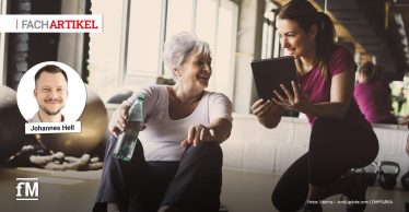 Oben links steht der rote und schwarze Schriftzug „FACHARTIKEL“ auf weißem Hintergrund. Links darunter befindet sich ein rundes Porträt eines Mannes mit der Beschriftung „Johannes Hell“. Im Vordergrund sitzt eine ältere Frau mit Wasserflasche auf einer Matte, rechts kniet eine Trainerin mit Tablet neben ihr. Unten links steht das weiße Logo „fM“, unten rechts der Text „Fotos: liderina – stock.adobe.com | DHfPG/BSA“ auf dunklem Hintergrund.
