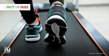 Person läuft in Sportschuhen auf einem Laufband, Fokus auf die Füße und die Bewegung während des Trainings.
