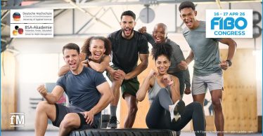 Gruppe von Fitnesssportlern im Studio feiert gemeinsam Trainingserfolg und Teammotivation