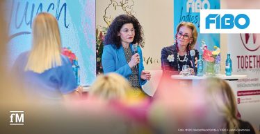Zwei Frauen sprechen auf einer Bühne bei einem Panel-Talk auf der FIBO.