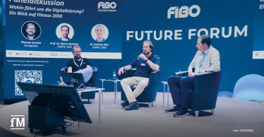 Drei Männer sitzen bei einer Podiumsdiskussion auf dem FIBO Future Forum.