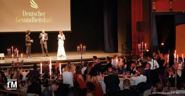 Moderation auf der Bühne vor Gästen an runden Tischen im Capitol Theater Offenbach